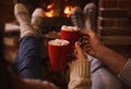 Lovely couple with sweet cocoa near fireplace indoors, closeup