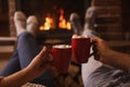 Lovely couple with sweet cocoa near fireplace indoors