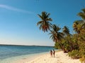 Lovely couple walking at the white sandy beach with palm trees in Onok Island in Balabac Philippines Royalty Free Stock Photo