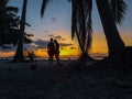 Couple watching sunset with palm trees in Candaraman Island in Balabac Philippines Royalty Free Stock Photo