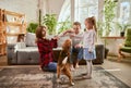 Lovely cute family, parents and child relaxing at home, playing with beagle dog in their living room on sunny day Royalty Free Stock Photo