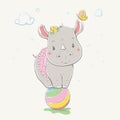 Lovely cute rhino stands on the colorful ball. Young dressed rhino in the children`s summer sundress in polka dots, with the
