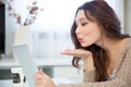 Lovely cute young woman using tablet and sending a kiss Royalty Free Stock Photo