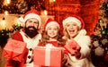 Lovely daughter with parents wearing Santa hat. Gifts from Santa. Caring closest people. Togetherness concept. Love and