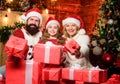 Lovely daughter with parents wearing Santa hat. Togetherness concept. Love and kindness. Father Santa claus costume with