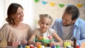 Lovely family with cute daughter painting eggs for Easter, entertainment center Royalty Free Stock Photo