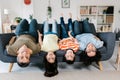 Lovely family looking at camera and smiling while lying on the sofa upside down. Royalty Free Stock Photo