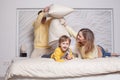 Lovely family, parents with adorable child son playing with pillows Royalty Free Stock Photo