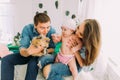 The lovely family photo of the woman holding the baby and man showing him the rabbit in the childroom.