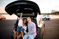 Lovely family are resting while sitting on the trunk of the car Royalty Free Stock Photo