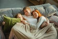 Family spending nice time together at home, looks happy and cheerful, lying down together