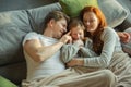 Family spending nice time together at home, looks happy and cheerful, lying down together