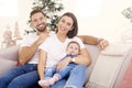 Lovely family with their baby girl relaxing on sofa at home during Christmas Royalty Free Stock Photo