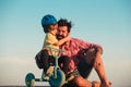 Lovely father teaching son riding bike. Happy dad helping excited son to ride a bicycle. Young smiling boy wearing Royalty Free Stock Photo