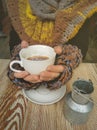 Lovely female hands holding a white Cup of hot coffee. A girl in a Cozy warm knitted sweater holding a Cup of hot coffee Royalty Free Stock Photo