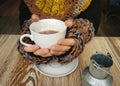 Lovely female hands holding a white Cup of hot coffee. A girl in a Cozy warm knitted sweater holding a Cup of hot coffee Royalty Free Stock Photo