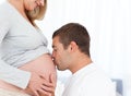 Lovely future dad kissing the belly of his wife Royalty Free Stock Photo
