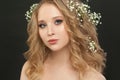 Lovely girl with blonde curly hair and flowers, beautiful face closeup Royalty Free Stock Photo