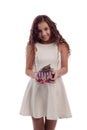 Lovely girl brunette with long hair in a white dress with a small gray kitten in a gift box in his hands on a white background in Royalty Free Stock Photo