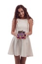 Lovely girl brunette with long hair in a white dress with a small gray kitten in a gift box in his hands on a white background in Royalty Free Stock Photo