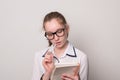 Lovely girl in glasses with a notebook. Young girl holds a notebook and pen.