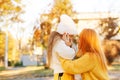 Lovely girl with her mom hugging on autumn walk. Autumn holidays, lifestyle