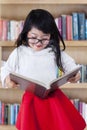 Lovely girl holding a book in library Royalty Free Stock Photo