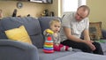 Lovely girl and loving father play colorful pyramid rings. Man commend daughter