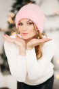 Lovely girl in pink woolen beanie hat making air kiss with hands. Royalty Free Stock Photo