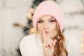 Lovely girl in pink woolen beanie hat making air kiss with hands. Royalty Free Stock Photo
