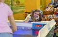 Lovely girl playing air hockey game with her mum at kids amusement center Royalty Free Stock Photo