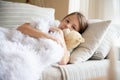 Lovely girl is sick under the blanket and hugs the teddy bear.