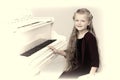 Lovely girl sitting at piano. Studio portrait.