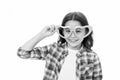 Lovely glance. Kid girl heart shaped eyeglasses cheerful. Girl curly hairstyle adorable smiling face. Child charming