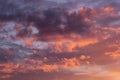 Lovely golden, purple and pink clouds in blue heaven with soft haze on sunset as abstract background, texture.