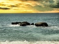 Lovely golden sunset on Pacific Ocean with large rocks