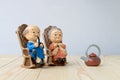 Lovely grandparent doll siting old sofa classic chair together on wooden table with background.