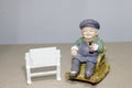 Lovely grandparent doll siting rocking bamboo chair on wood background. -still life.