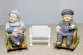 Lovely grandparent doll siting rocking bamboo chair on wood background. -still life.