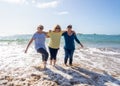 Group of three senior women walking having having fun on beach. Friendship and healthy lifestyle Royalty Free Stock Photo