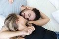 Lovely happy couple in love, and kiss each other on their bed in the bedroom Royalty Free Stock Photo