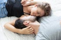 Lovely happy couple in love, smile, and kiss each other on their bed in the bedroom Royalty Free Stock Photo