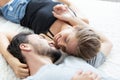 Lovely happy couple in love, smile, and kiss each other on their bed in the bedroom Royalty Free Stock Photo