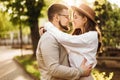 Lovely happy couple smiling and hugging in the sun. A beautiful girl and a young guy are hugging on the street in summer Royalty Free Stock Photo