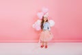 Lovely happy moments of little amazing girl with long brunette hair having fun with balloons  on pink background Royalty Free Stock Photo