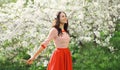 Lovely happy smiling young woman in spring blooming garden with flowers on the trees in park Royalty Free Stock Photo