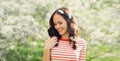 Lovely happy smiling young woman in spring blooming garden with white flowers on the trees in park Royalty Free Stock Photo