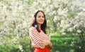 Lovely happy smiling young woman in spring blooming garden with white flowers on the trees in park Royalty Free Stock Photo