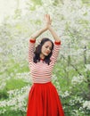 Lovely happy smiling young woman in spring blooming garden with white flowers on the trees in park Royalty Free Stock Photo