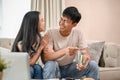 A lovely, happy young Asian new married couple is planning their savings together in the living room Royalty Free Stock Photo